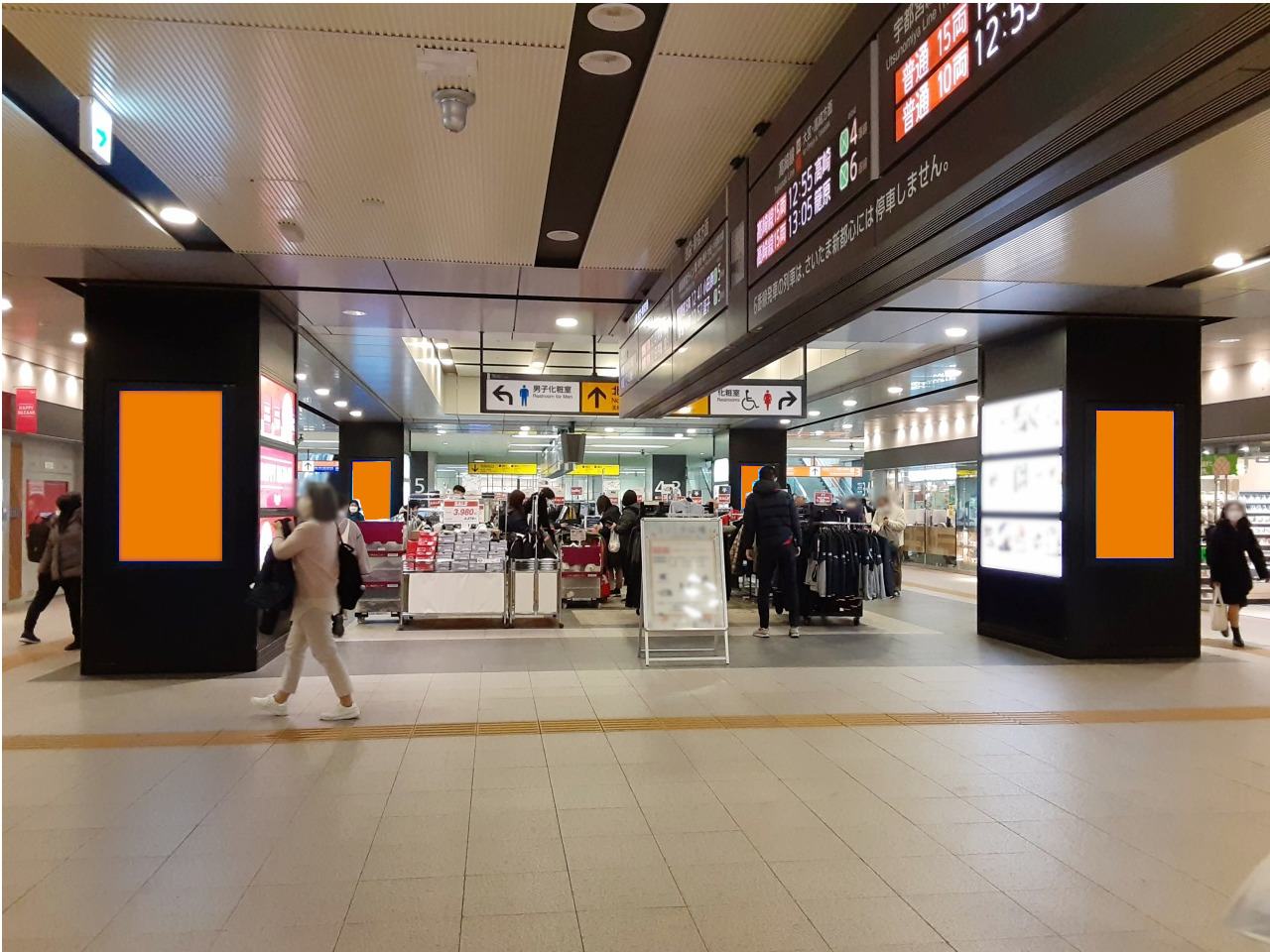 赤羽駅の北改札内で展開する縦型のデジタルサイネージ広告の写真です