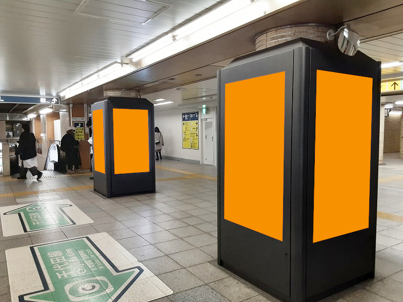 北千住駅の構内で展開する縦型のデジタルサイネージ広告の写真です