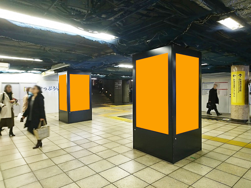 有楽町駅の構内で展開する縦型のデジタルサイネージ広告の写真です