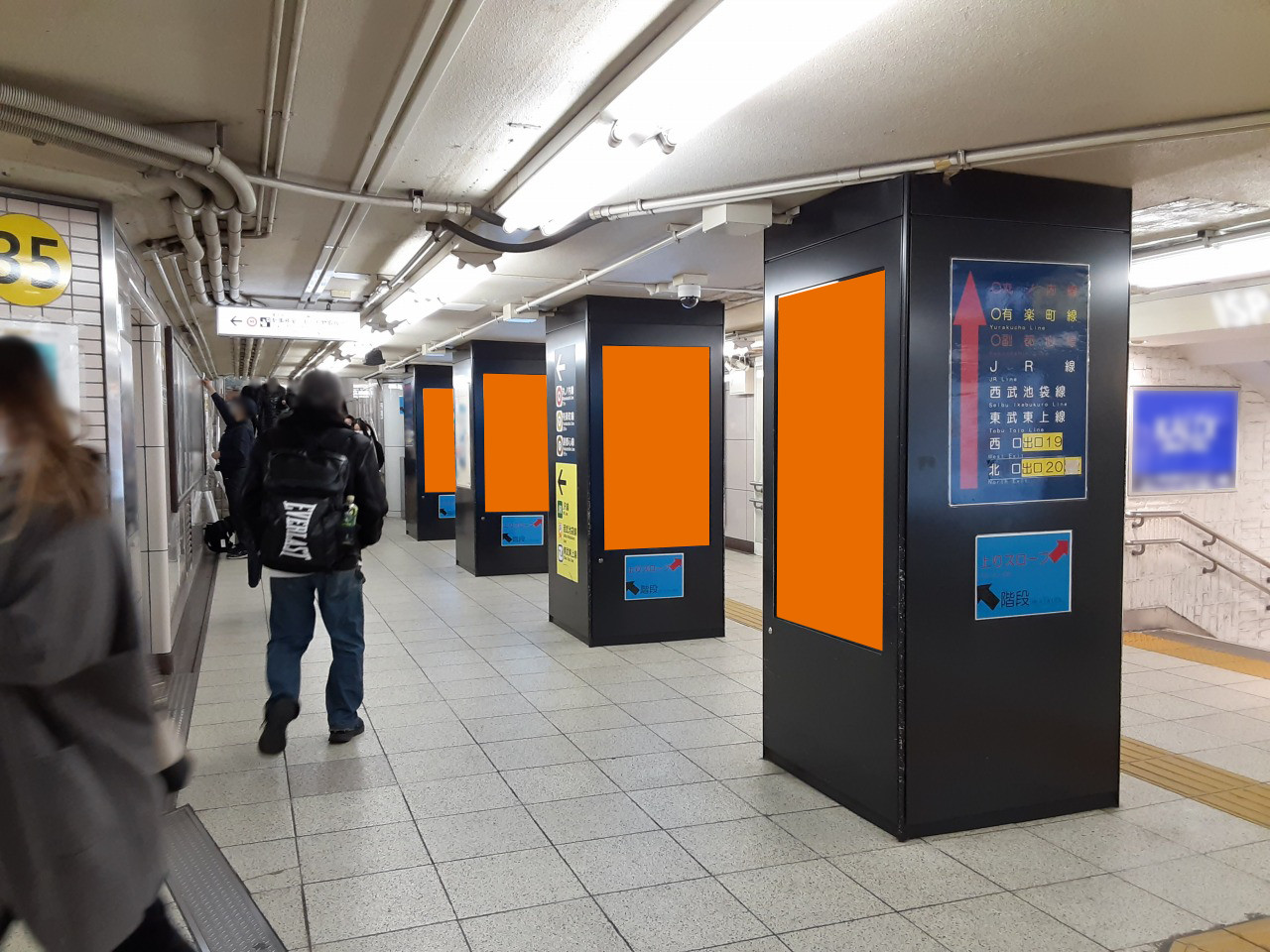 池袋駅の構内で展開する縦型のデジタルサイネージ広告の写真です