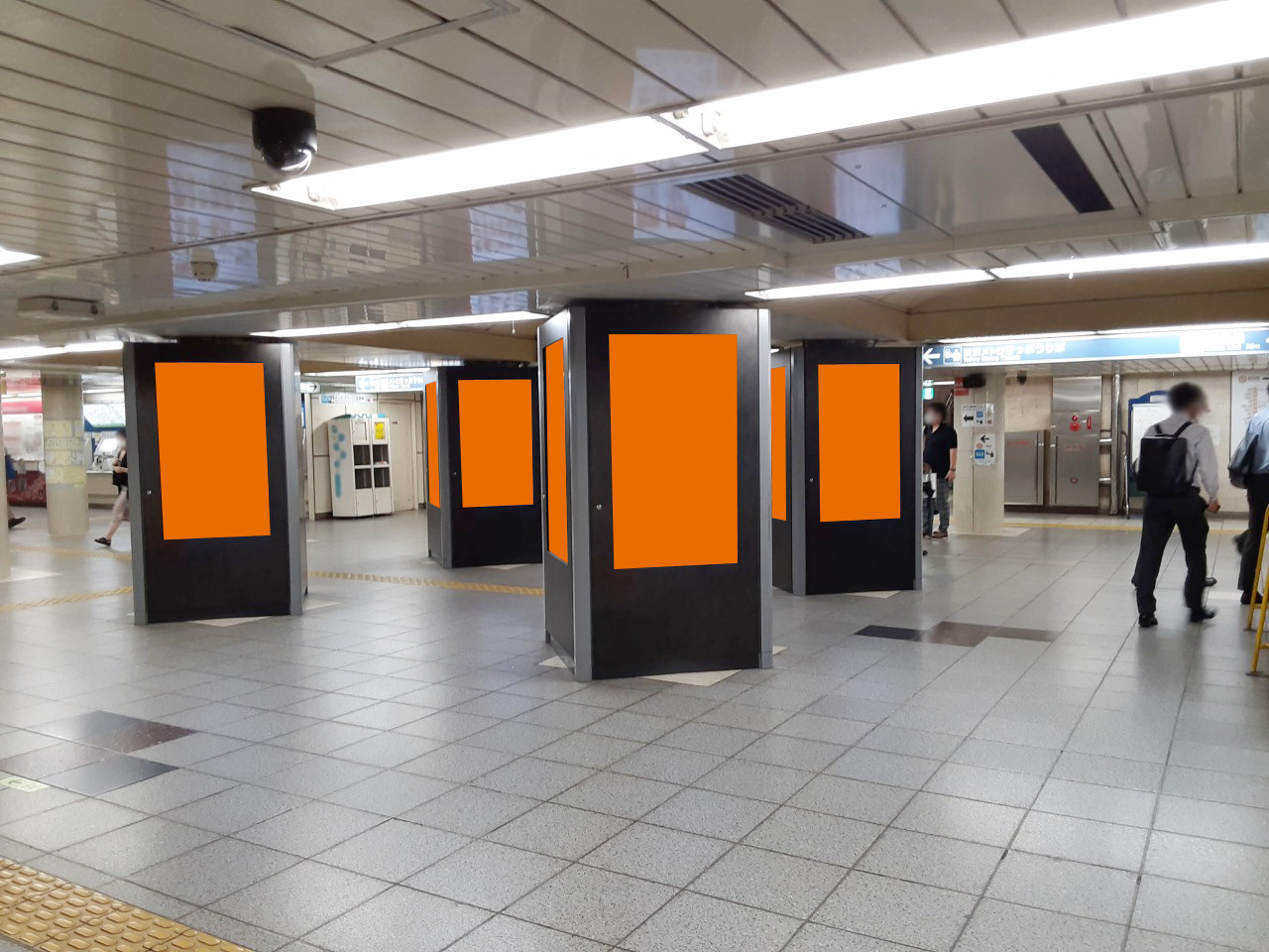 新橋駅の構内で展開する縦型のデジタルサイネージ広告の写真です